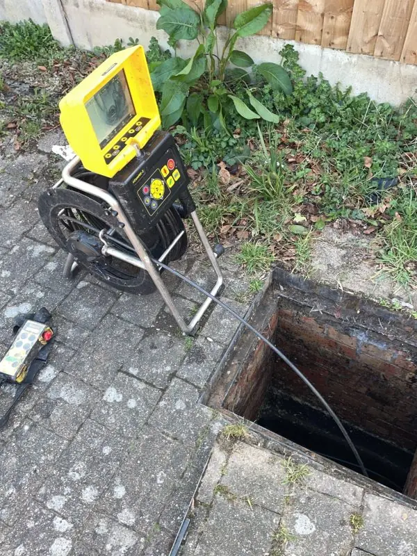 CCTV survey unit beside an open manhole