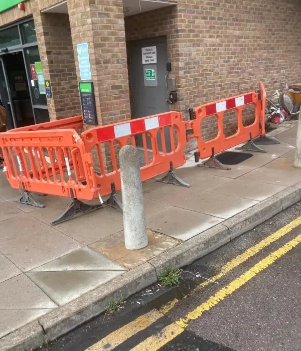 Safety barriers around an open drain on a pavement