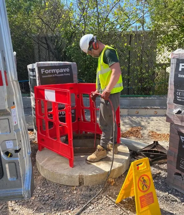 Engineer in full PPE behind safety barriers