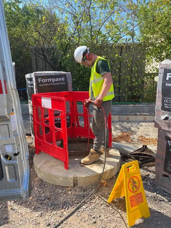 Engineers working behind barriers in full PPE