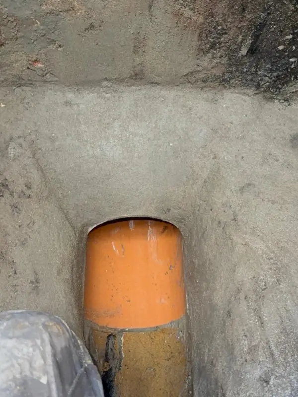 New orange PVC pipe connected into an old run